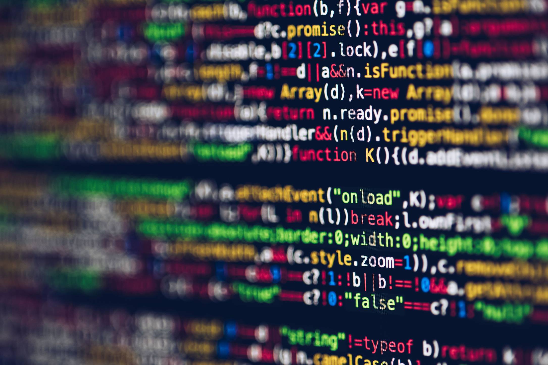 Close view of a monitor showing software test output with colorful code on a screen